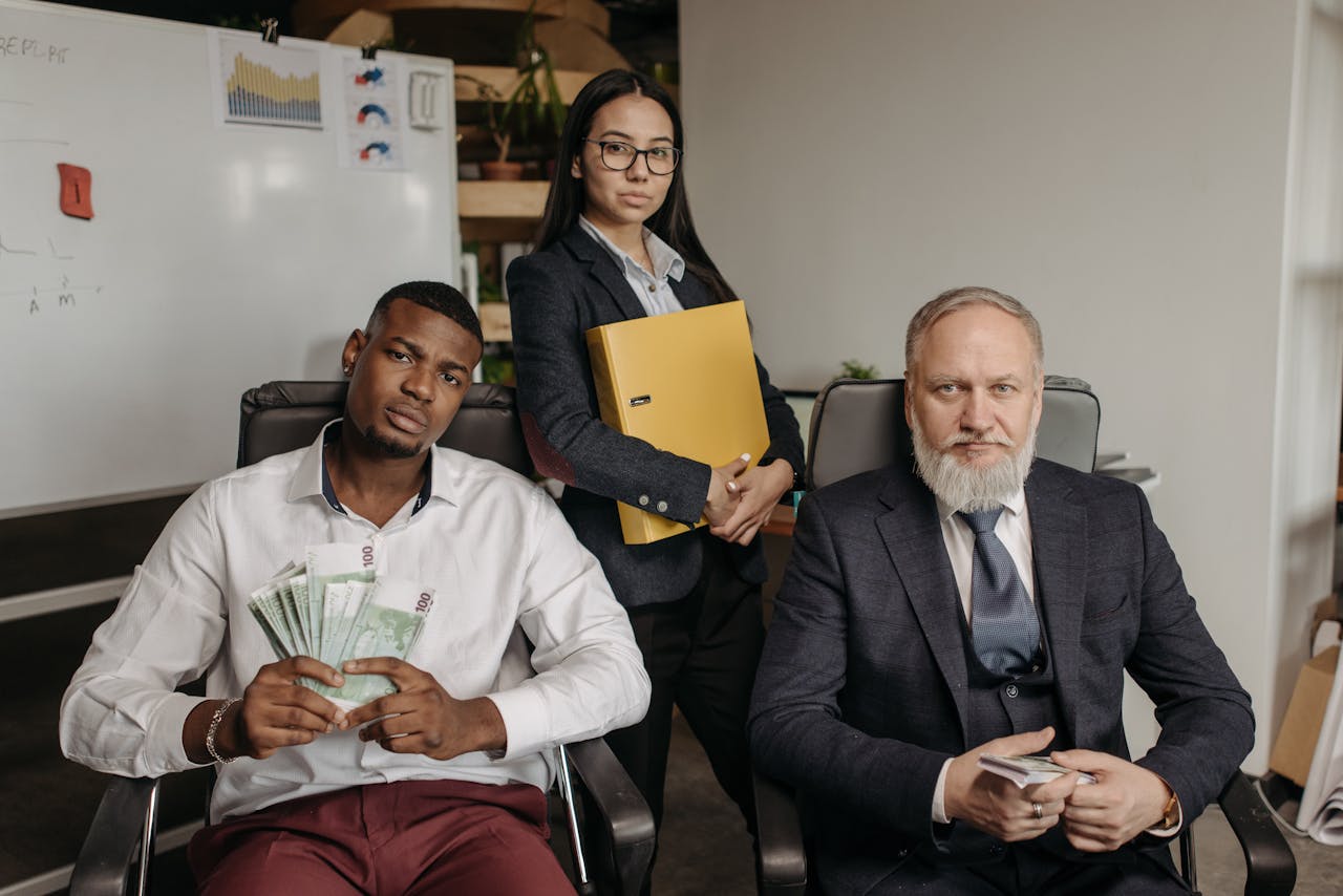 about-img Three business professionals in an office setting exuding teamwork and financial success.